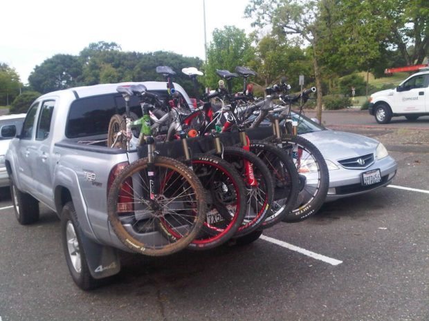 Toyota Tacoma with a tailgate pad moving 5 Mountain Bikes